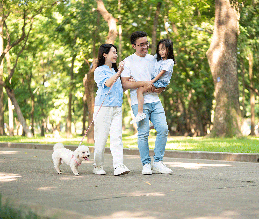 Family walking in park with dog near homes
